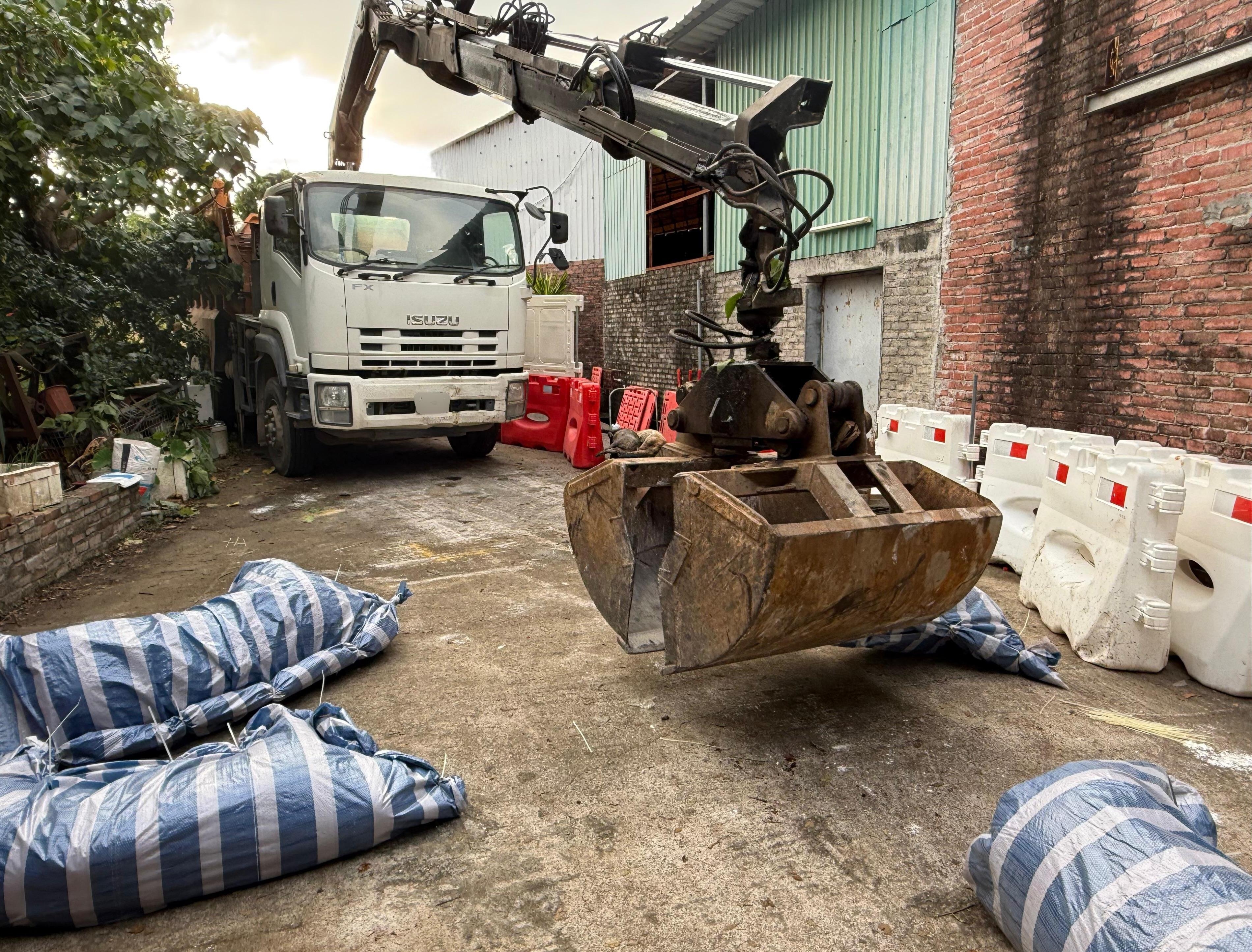 圖示漁護署安排車輛把包裹的豬隻屍體移離涉事豬場。（漁護署圖片）
