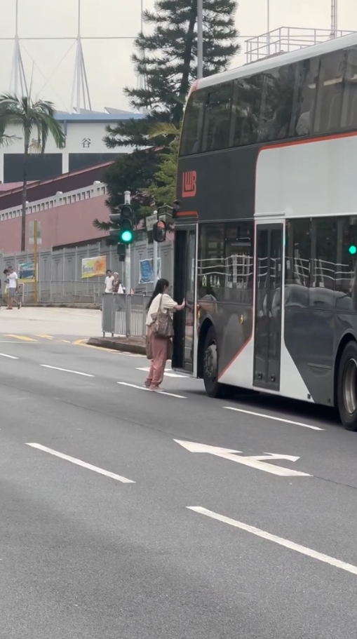 女子荃灣衝馬路拍門追巴士勁牙煙，司機終開門放行被網民鬧爆。(影片截圖／Threads@z.oeyi)