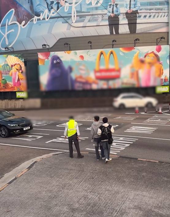 兩男誤闖紅隧口過馬路，最後要職員帶走。(T@nicola223)