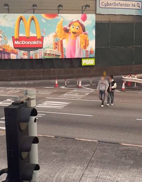 兩男誤闖紅隧口過馬路，最後要職員帶走。(T@nicola223)