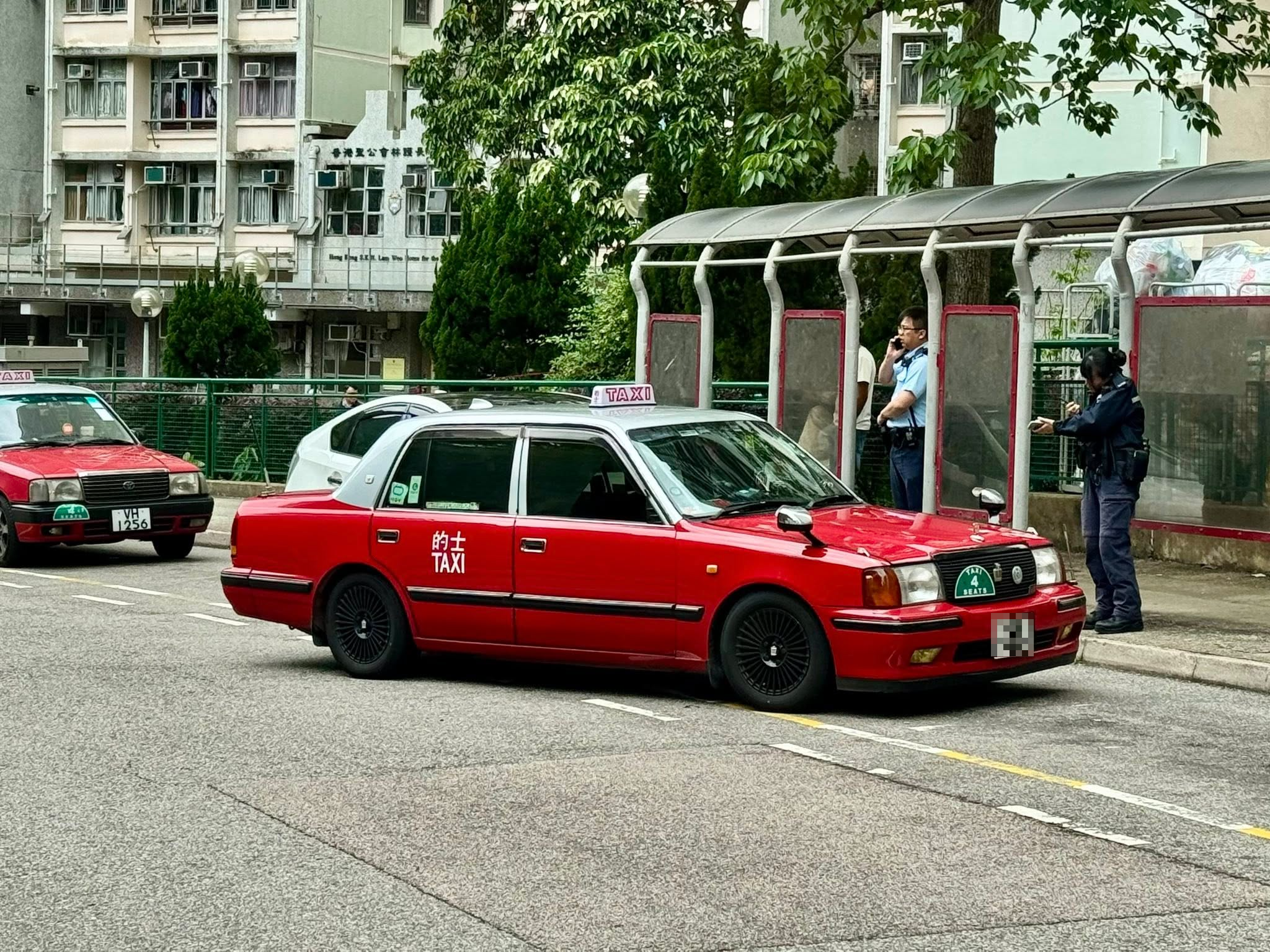 現場一輛白色私家車和一輛的士停在澤蔭樓對開的士站，的士「斜插」在私家車前方，白色私家車司機位的車門凹陷。（Facebook圖片／馬路的事 (即時交通資訊台)／Him Tang）