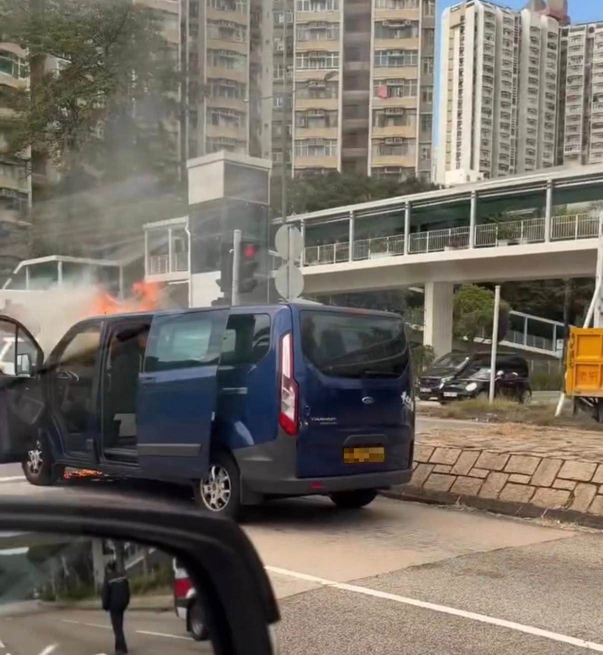 涉事客貨車停泊在青田路與鳴琴路交界的燈位前，車輛陷入火海，大量濃煙冒出，直衝半空，警方及消防人員趕到現場處理事件。（Facebook圖片／車cam L（香港群組）／Bosco Chu）