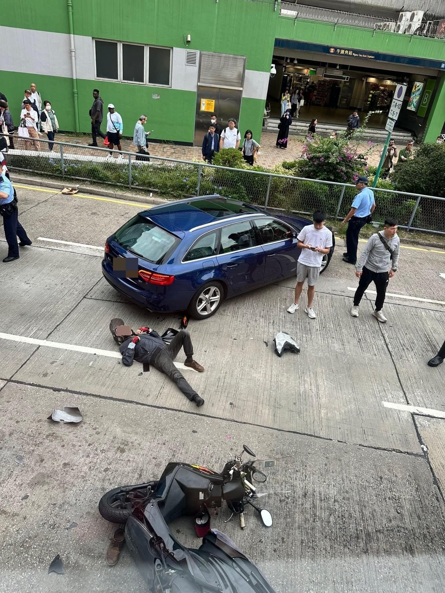 港鐵牛頭角站B出口對開位置。一輛「綿羊仔」電單車與一輛Audi私家車發生碰撞，鐵騎士應聲倒地。