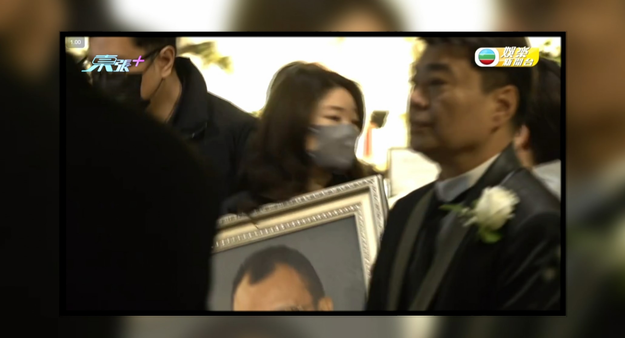 女兒許惠菁則捧着遺照出靈堂。