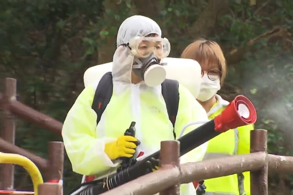 有穿上全套防護衣物的食環署職員，在青衣自然徑北面入口，向草叢噴滅蚊噴霧。（網上圖片）