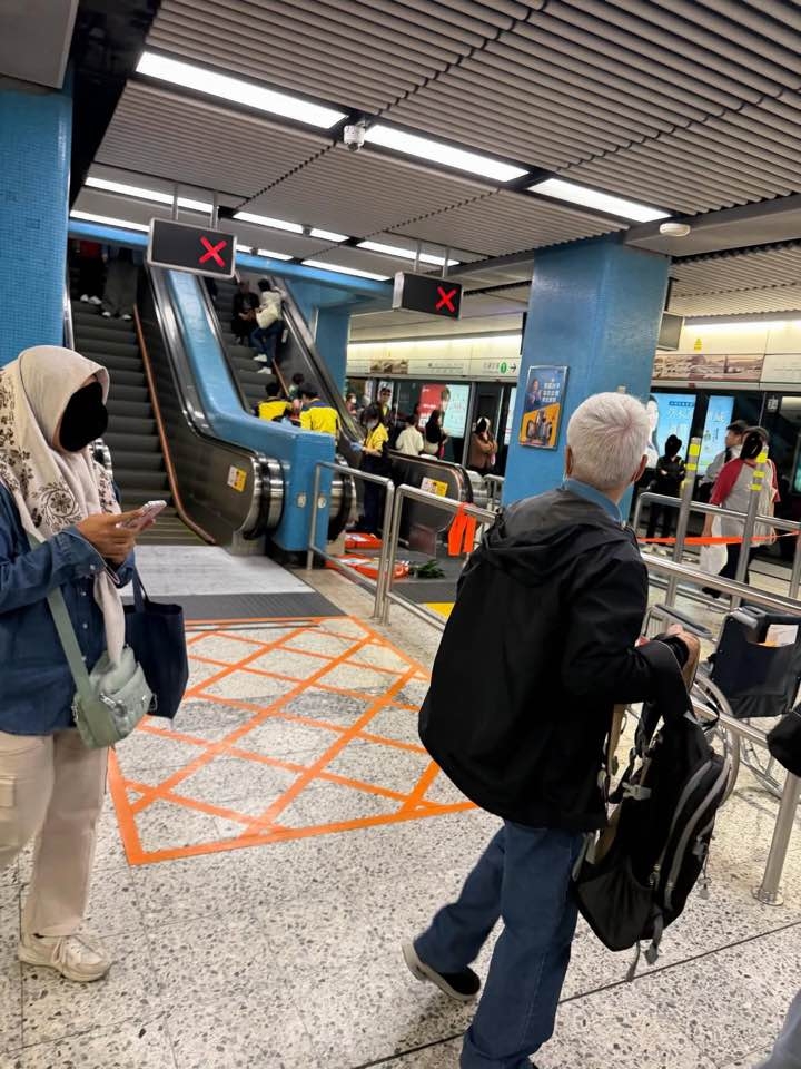 網上相片顯示，港鐵九龍塘站一條由月台上大堂的扶手電梯停止服務，有人坐在梯級上，港鐵職員正在現場處理事件。（Facebook圖片／車cam L（香港群組）／Soso Chan）