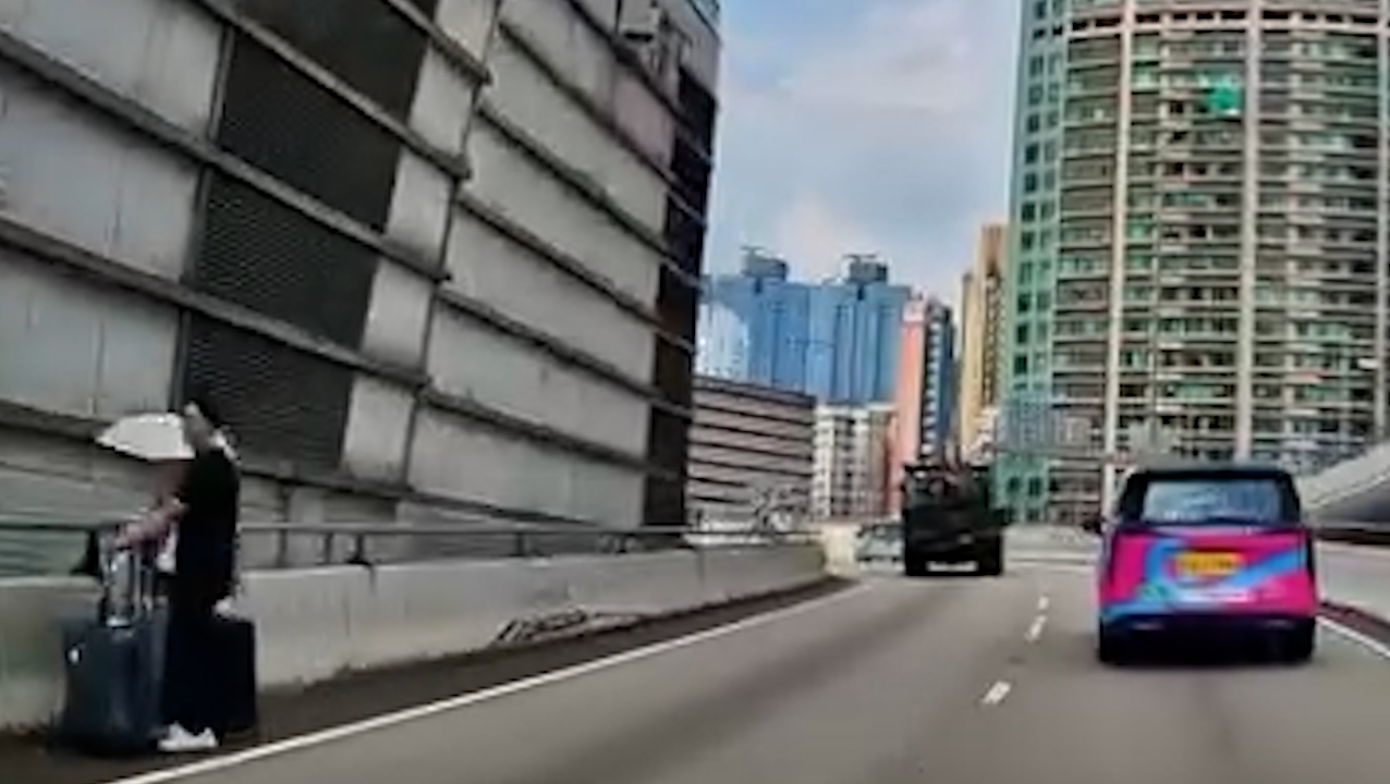 網上流傳一段車Cam片段，拍攝到一對男女在紅磡繞道路邊呆站，女方更撐着雨傘，兩人站在路邊並拖着兩件行李箱，身旁不時有車輛高速駛過，場面險象環生。