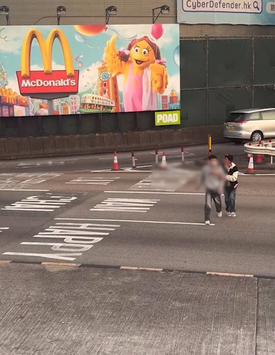 兩男誤闖紅隧口過馬路，最後要職員帶走。(T@nicola223)