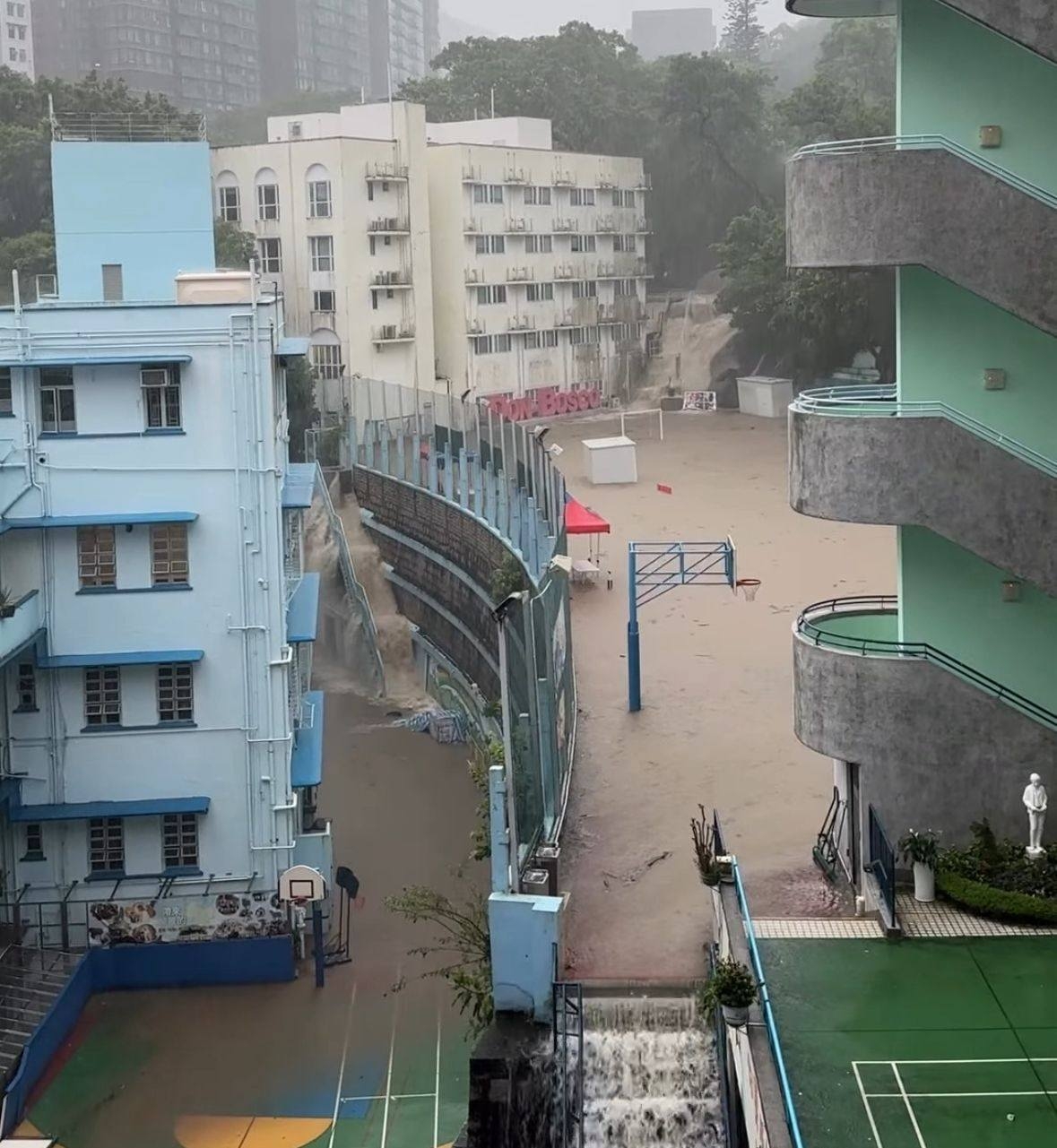 大量泥水從學校旁的山坡湧下，覆蓋了校園內的地勢較高的操場地面，如同「泳池」一樣。