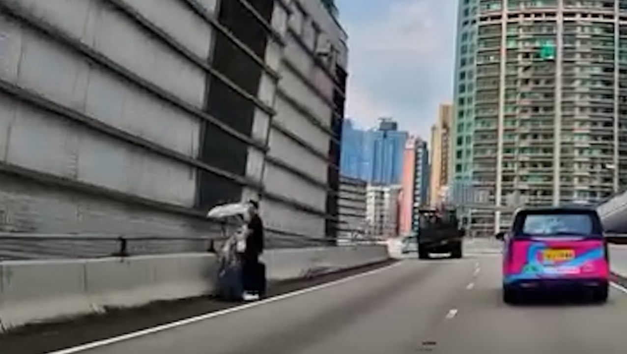 網上流傳一段車Cam片段，拍攝到一對男女在紅磡繞道路邊呆站，女方更撐着雨傘，兩人站在路邊並拖着兩件行李箱，身旁不時有車輛高速駛過，場面險象環生。