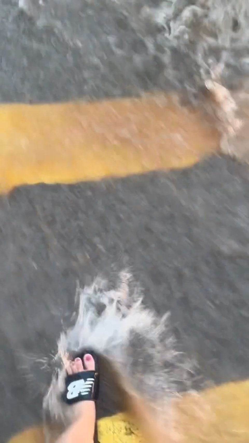 港女在「激流」中涉水橫過馬路上班。