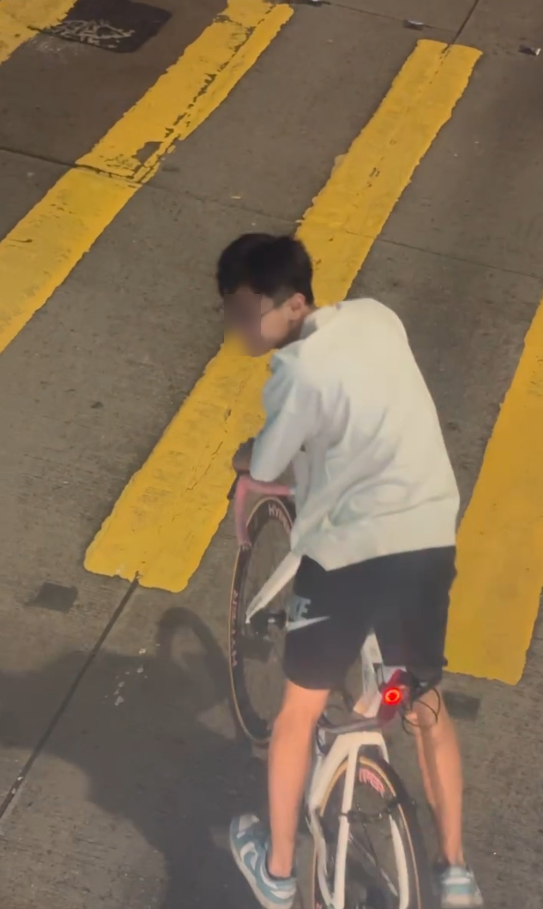 影片由巴士上層乘客向下拍攝，清晰可見少年騎單車停在馬路中央位置，巴士駛近時未有讓路。少年不但未有移動，反而回頭與旁人交談，神情輕鬆。