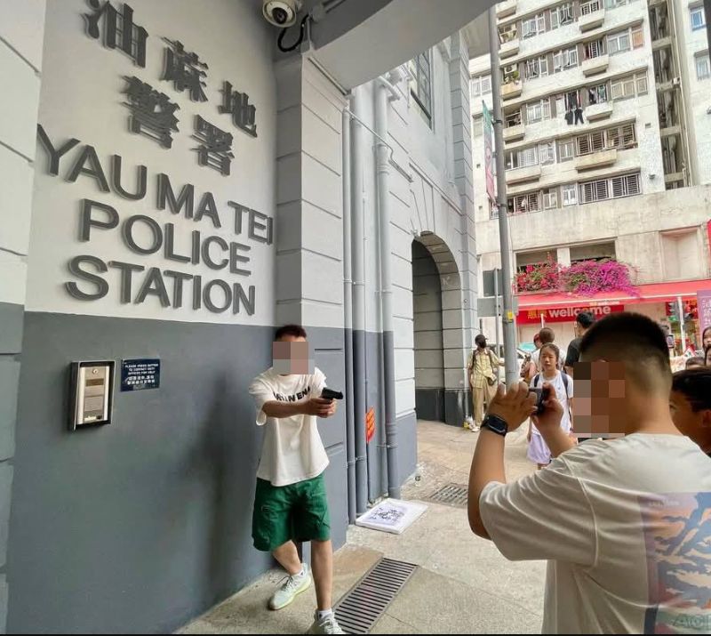 舊油麻地警署外內地客持仿製槍拍照