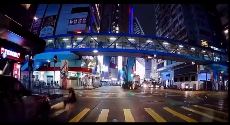 銅鑼灣內地女冒雨急步「衝紅燈」，插水跣入的士底險遭輾過。