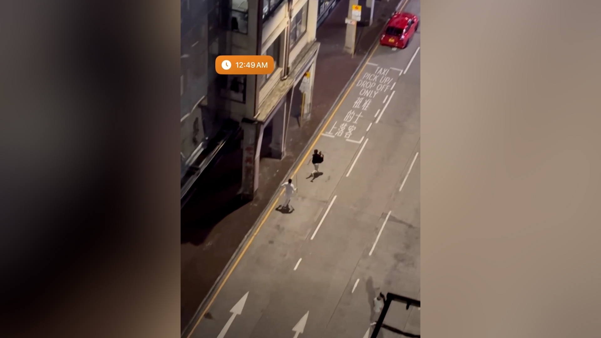 片段開始即聽到有人說「嚟啊」，隨後一名白衣男子手持棍橫過馬路，追逐一名手持背囊的黑衣男子