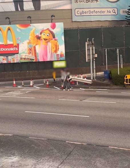 兩男誤闖紅隧口過馬路，最後要職員帶走。(T@nicola223)