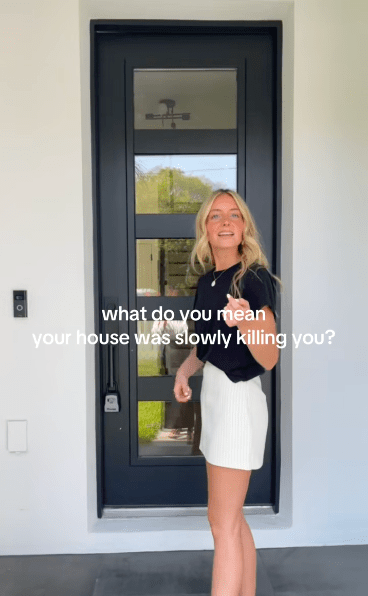 格蕾絲·克朗克賴特 (Grace Cronkright) 站在一扇現代化的前門旁，門上寫著：“你的房子正在慢慢殺死你，這是什麼意思？”