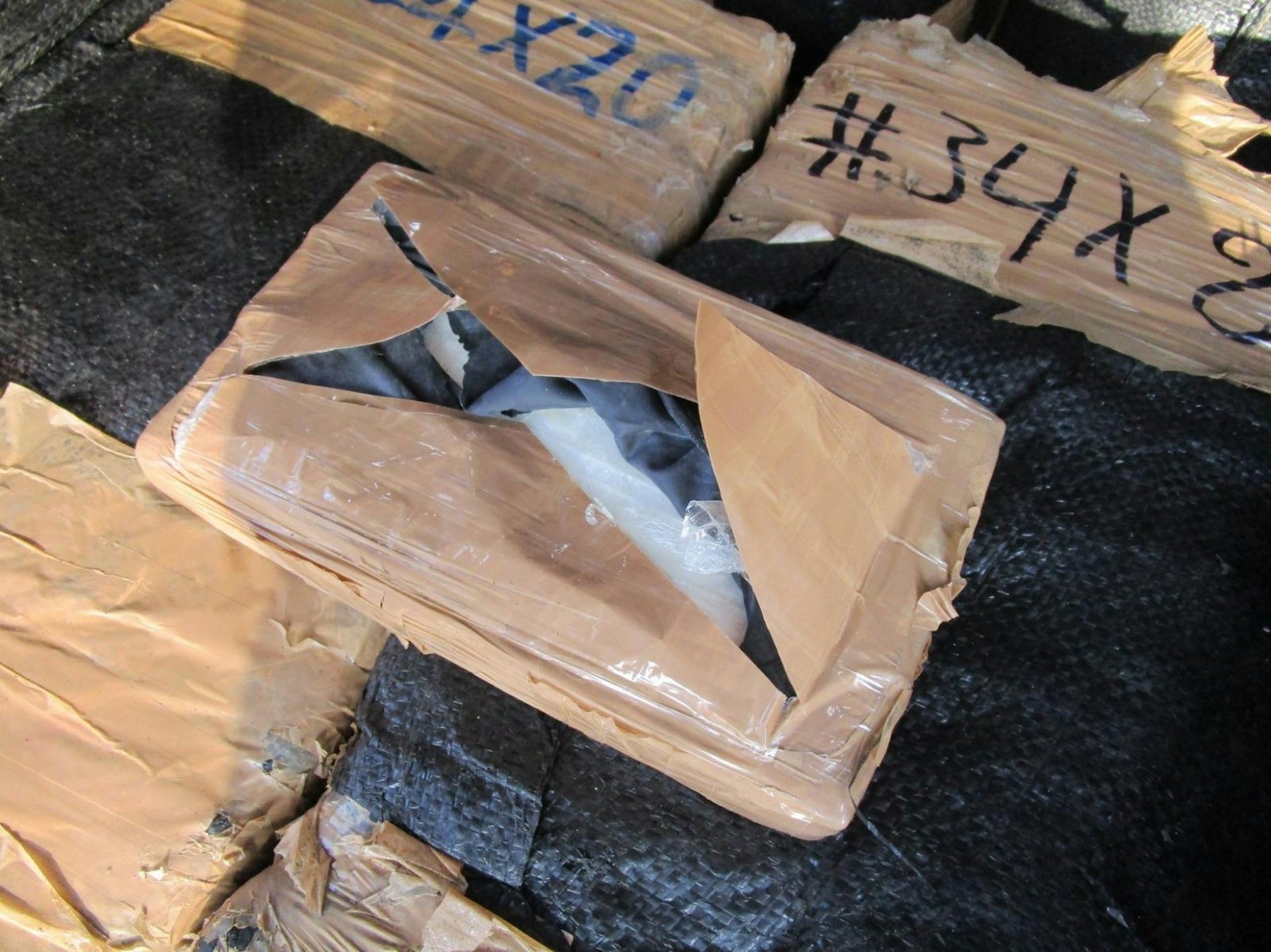 多重不透光膠紙包裹著懷疑可卡因磚。（警方YouTube直播截圖）