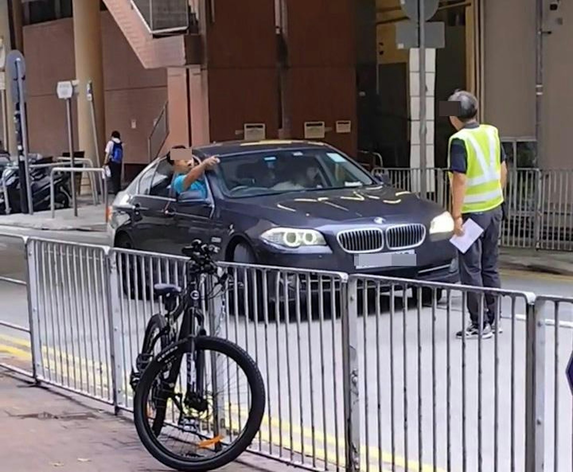 寶馬男司機探頭出窗，指罵保安，保安未有退開。