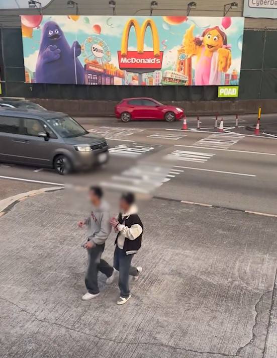 兩男誤闖紅隧口過馬路，最後要職員帶走。(T@nicola223)