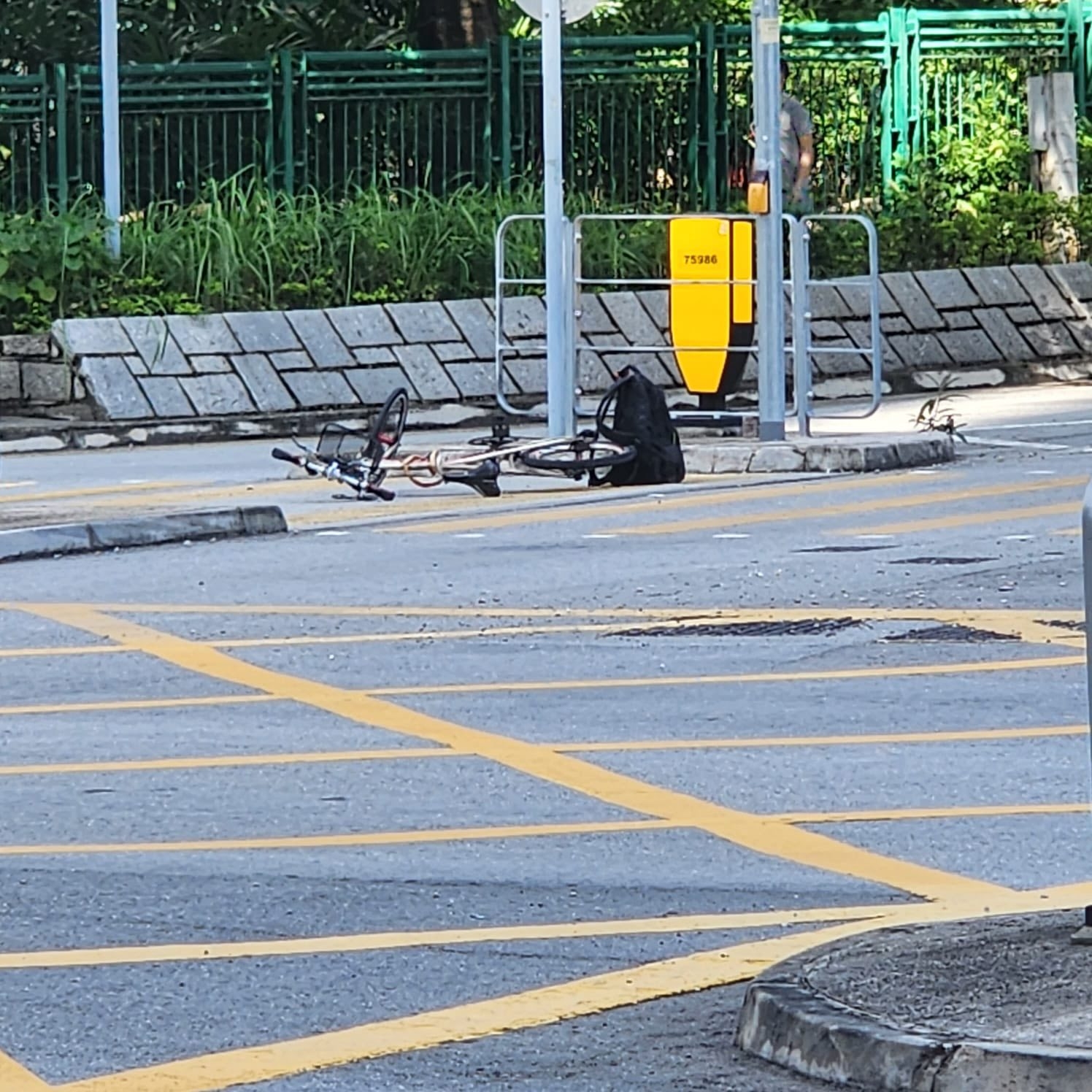 一輛單車被留在行人過路處中間的安全島地上，旁邊則遺有一個背囊。（Facebook圖片／車cam L（香港群組）／Bosco Chu）
