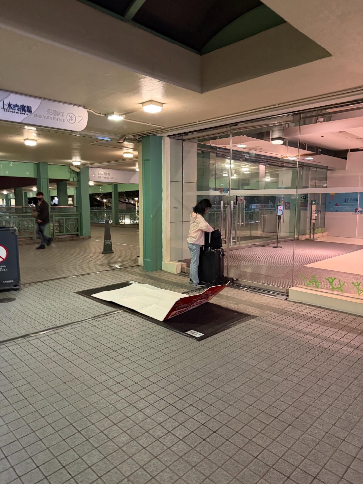 上水廣場疑內地旅客玩「窮遊」瞓街，舖紙毯攤消毒地毯過夜。 (網上圖片@threads)