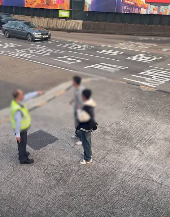 兩男誤闖紅隧口過馬路，最後要職員帶走。(T@nicola223)