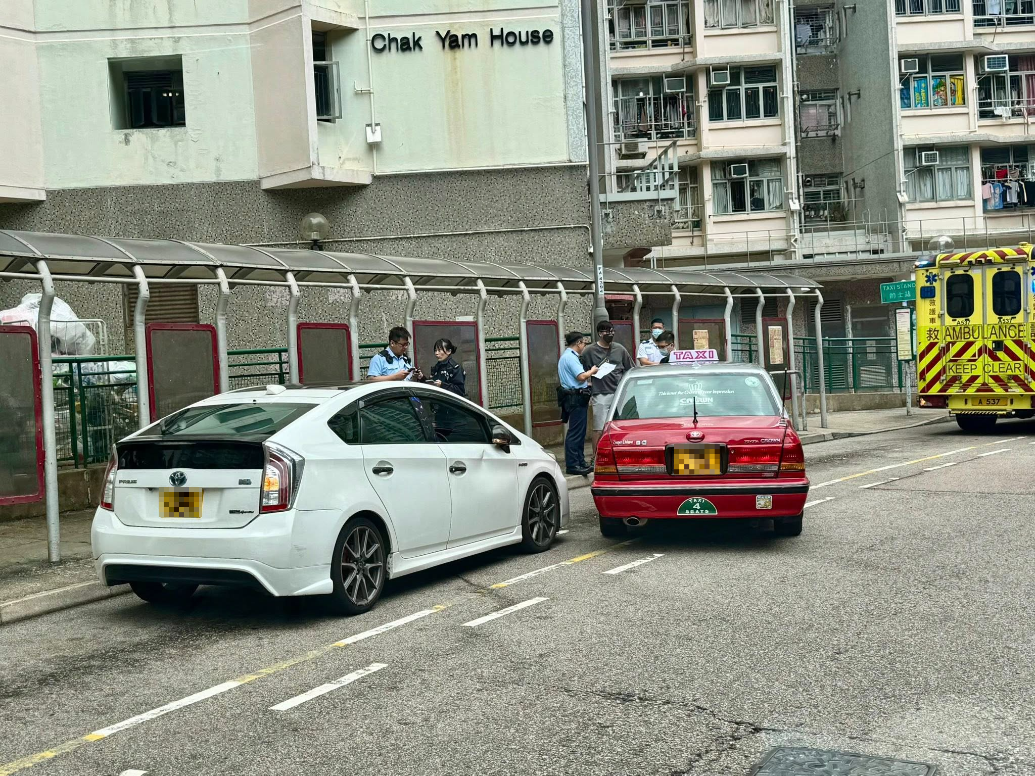 現場一輛白色私家車和一輛的士停在澤蔭樓對開的士站，的士「斜插」在私家車前方，白色私家車司機位的車門凹陷。（Facebook圖片／馬路的事 (即時交通資訊台)／Him Tang）