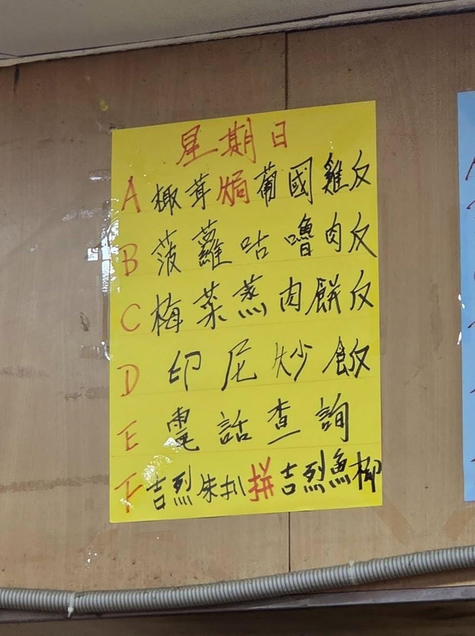 該間茶餐廳在牆壁貼著手寫餐牌，A至D餐，以及F餐均是正常飯餐，唯獨E餐竟寫上「電話查詢」，讓人一頭霧水。（Threads圖片／zero.cheng）