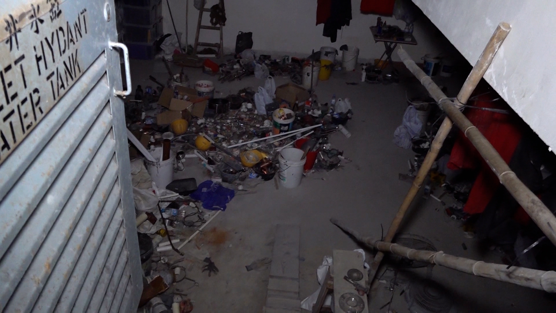 在陳先生所說的消防水缸現場所見，門並無上鎖，裏面漆黑一片，不過仍然可以看到裏面滿佈雜物，似乎真的被當成私人雜物房。