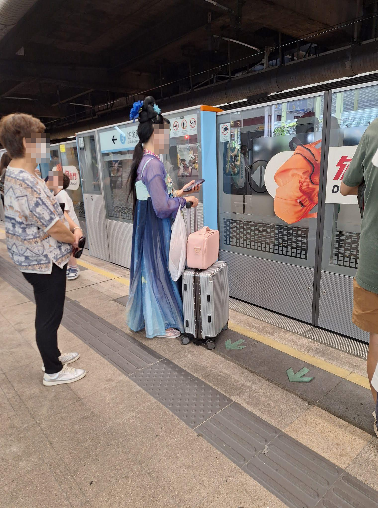 相中的「嫦娥」整裝待發，在往金鐘方向的東鐵線月台候車，其周圍亦站著其他候車的乘客。（Facebook圖片／大埔 TAI PO／Bosco Chu）
