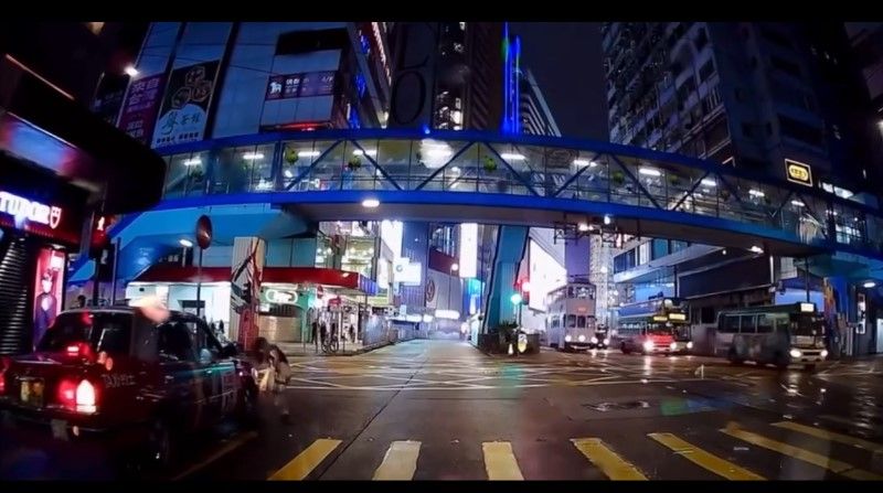 銅鑼灣內地女冒雨急步「衝紅燈」，插水跣入的士底險遭輾過。