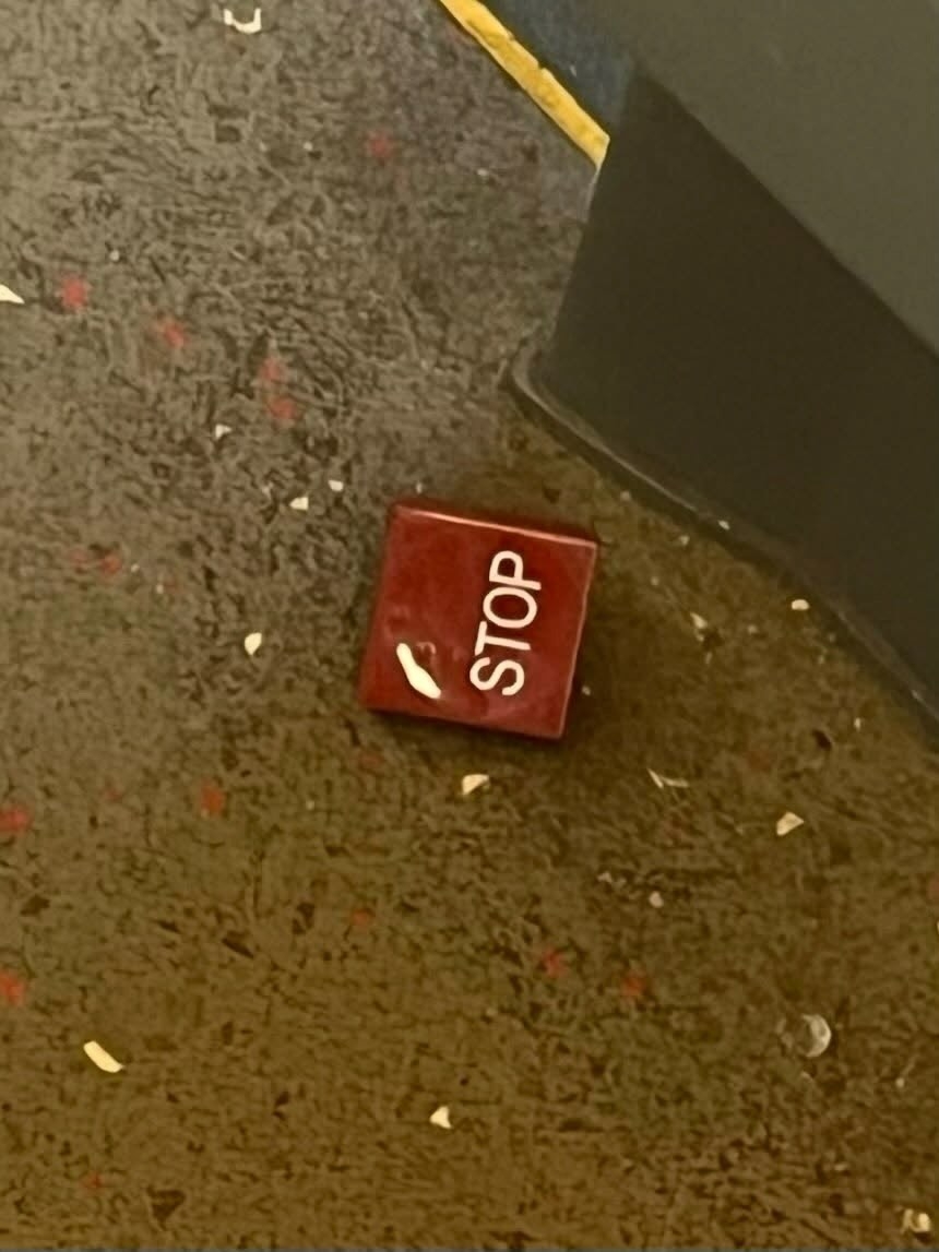 另一張圖片則清哳顯示寫著「STOP」的紅色按鈕掉在地板上