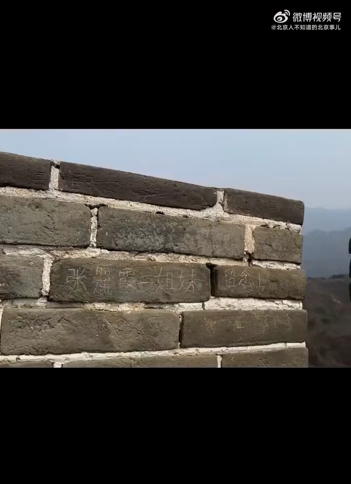 事後，城牆上可清晰看到「張麗、蕊霞姐妹留念」字樣。（網上影片截圖）