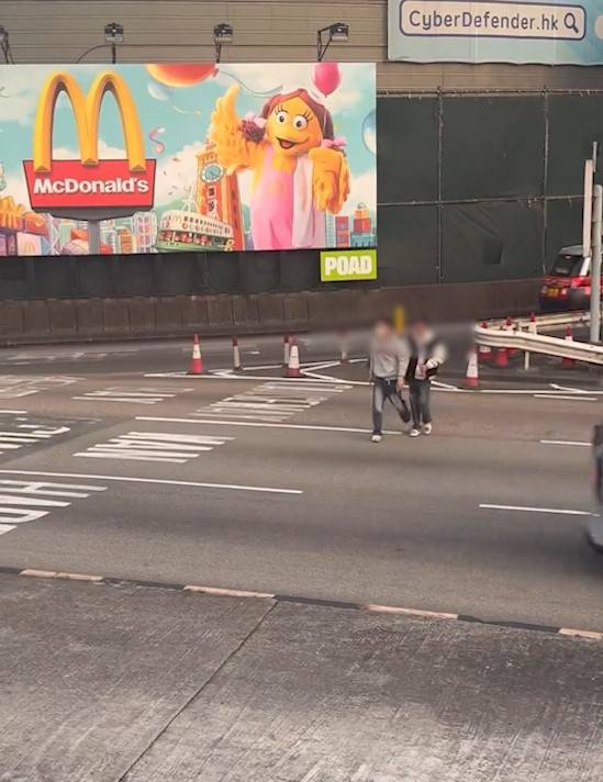 兩男誤闖紅隧口過馬路，最後要職員帶走。(T@nicola223)