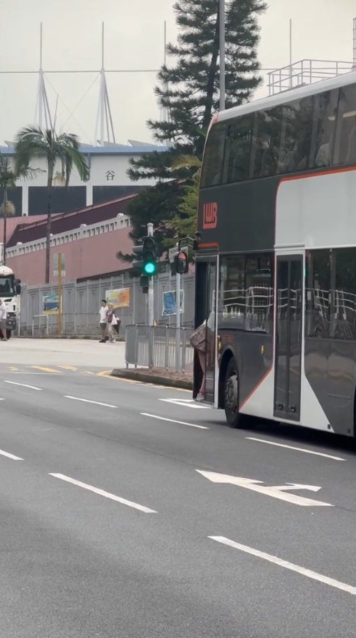 女子荃灣衝馬路拍門追巴士勁牙煙，司機終開門放行被網民鬧爆。(影片截圖／Threads@z.oeyi)