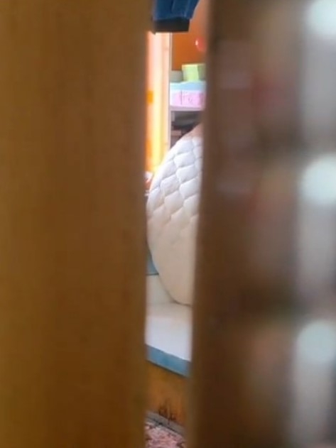 案發單位門外鐵閘以鐵鏈上鎖，大門半掩，可見睡房床邊和單位地上均有血跡。