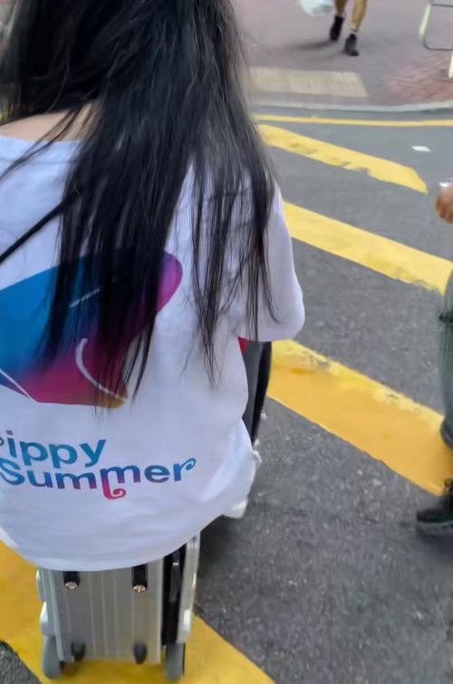 女子帶小孩騎電動行李箱周街走