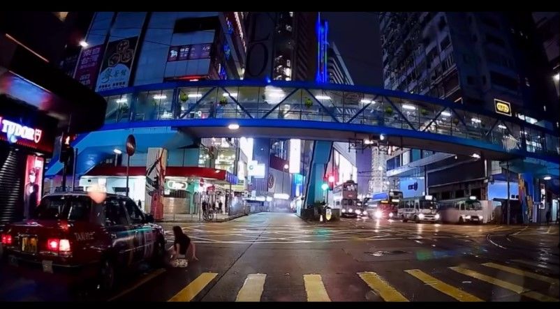 銅鑼灣內地女冒雨急步「衝紅燈」，插水跣入的士底險遭輾過。