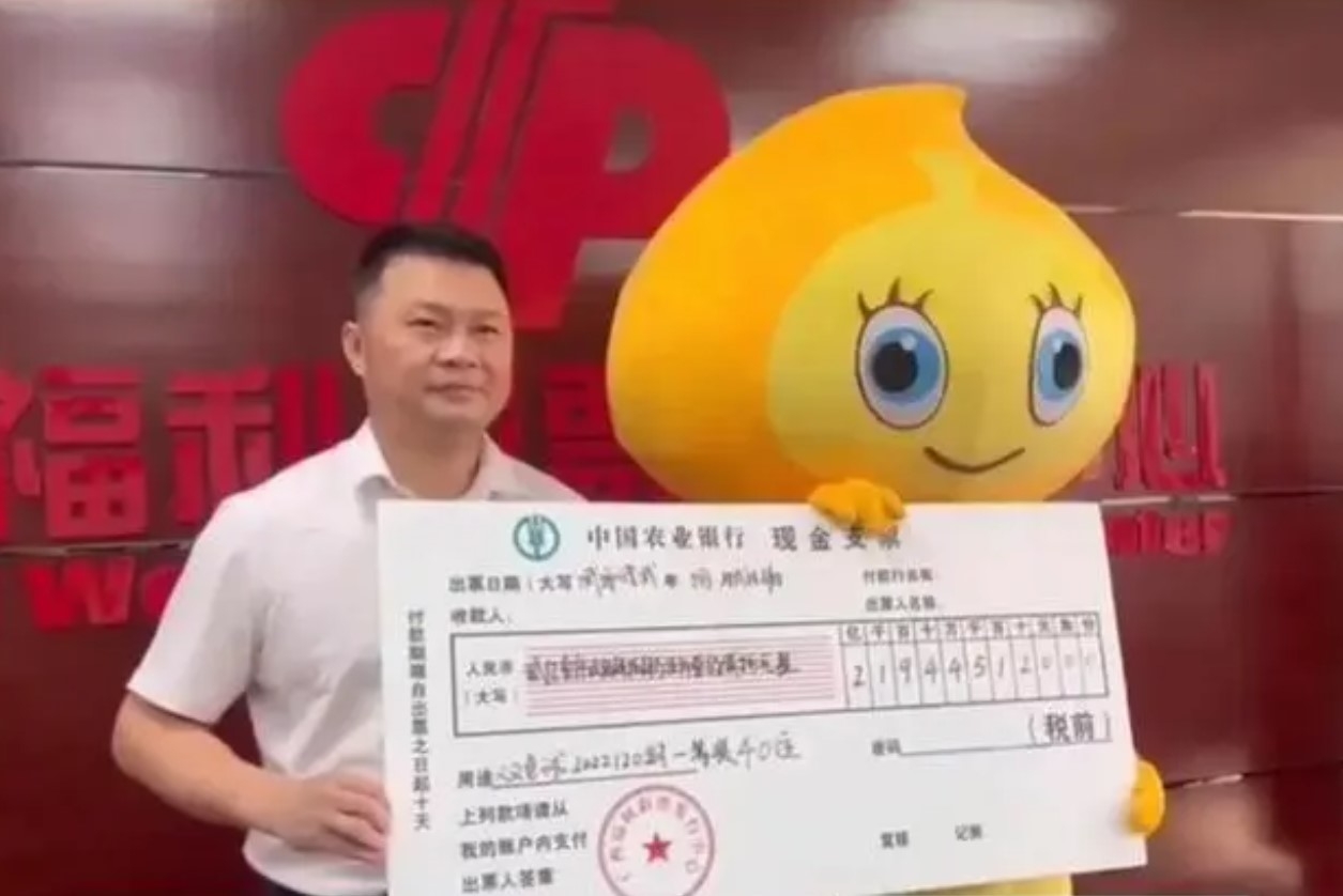 中獎者(右)身穿福彩吉祥物福豆頭套和服裝領獎。網絡圖片