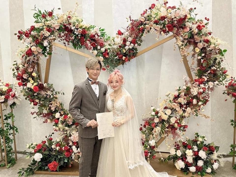 穿上大deep V婚紗的娜娜與另一伴手持結婚證書合照