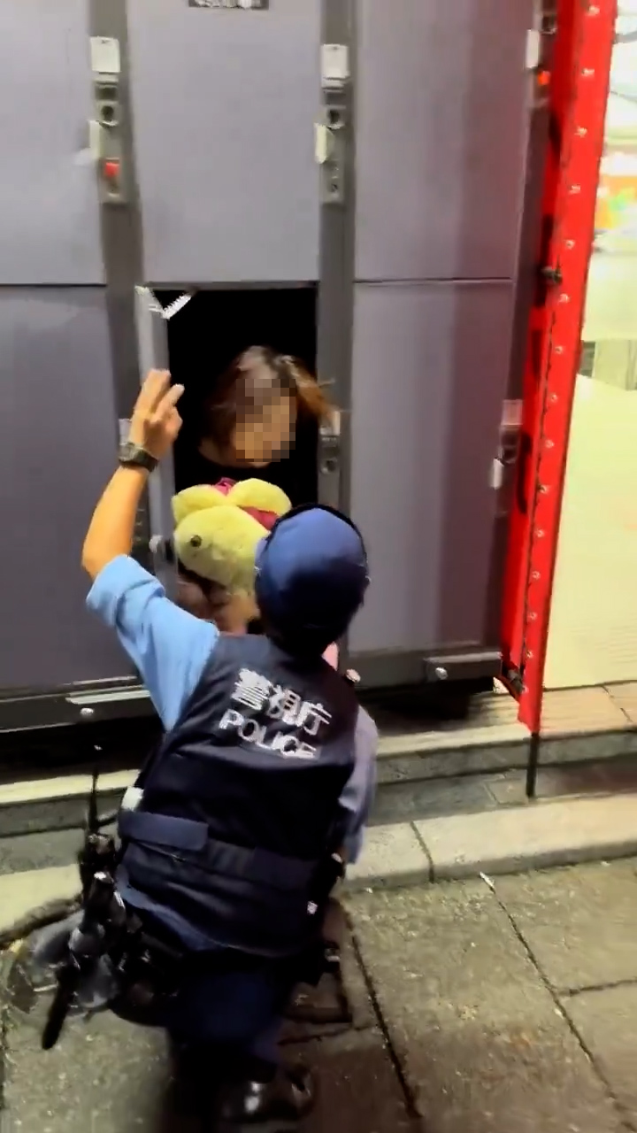 女子看來睡眼惺忪，疑似是蜷縮在儲物櫃裏睡覺，其後警員對女子進行查問。（「X」影片截圖／alex001050）