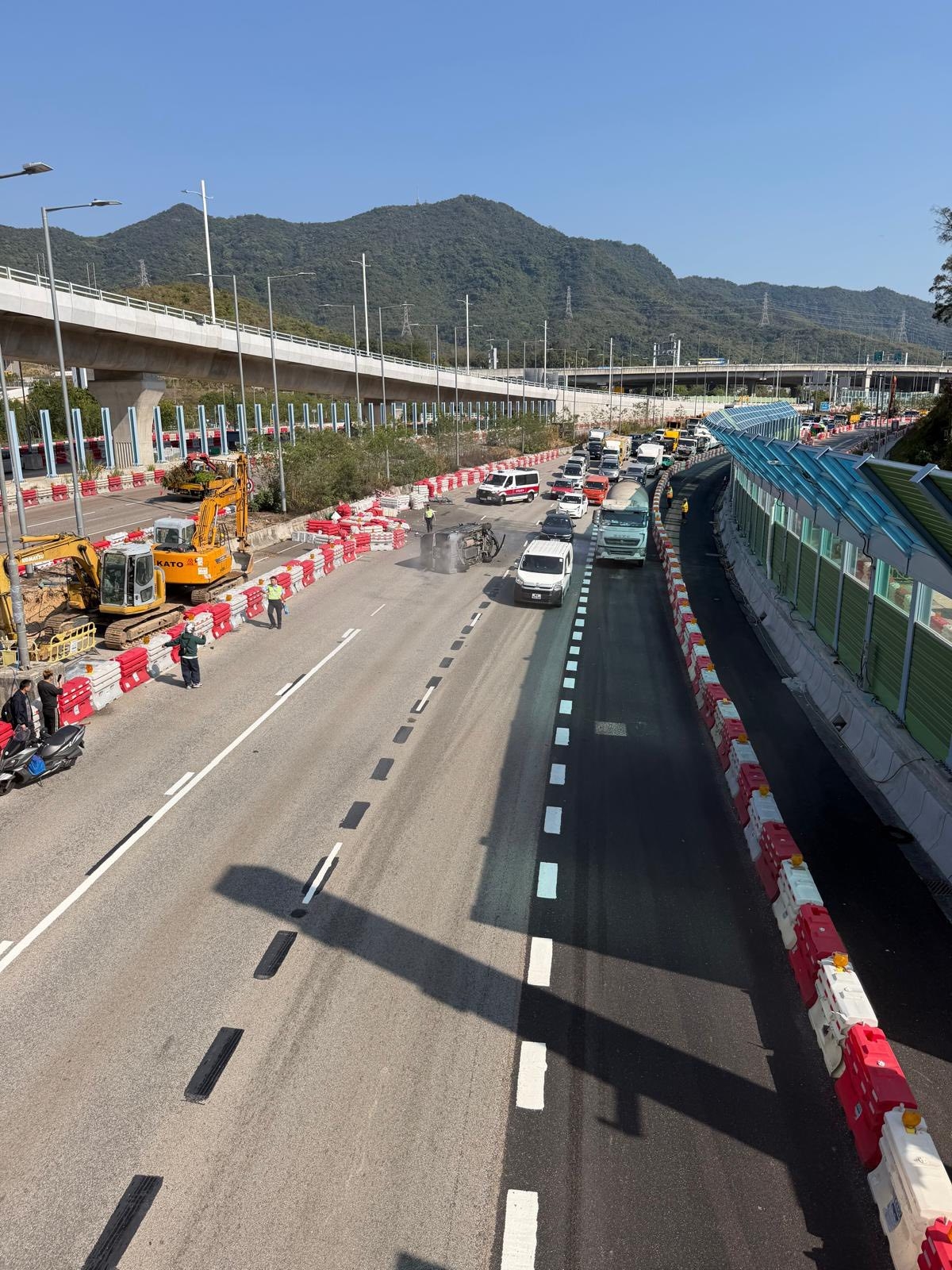涉事黑色私家車向左翻側，橫亘路中，車尾冒白煙，車頭嚴重損毀，零件碎片散落一地。（Facebook圖片／車cam L（香港群組）／Bosco Chu）