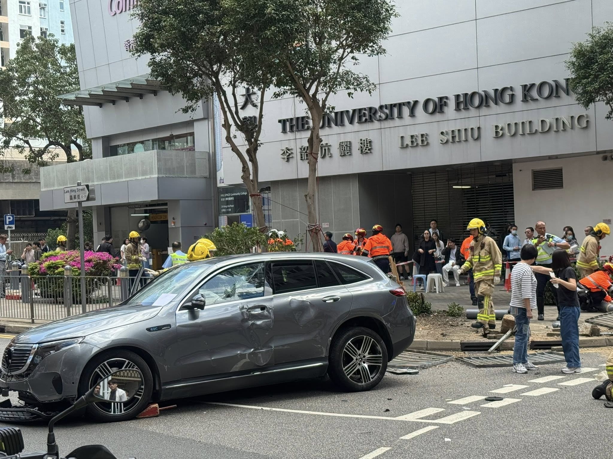 涉事私家車失事，撞斷欄杆剷上行人路，行人路上的樹倒塌，有傷者分別倒在行人路和馬路。（網上圖片）