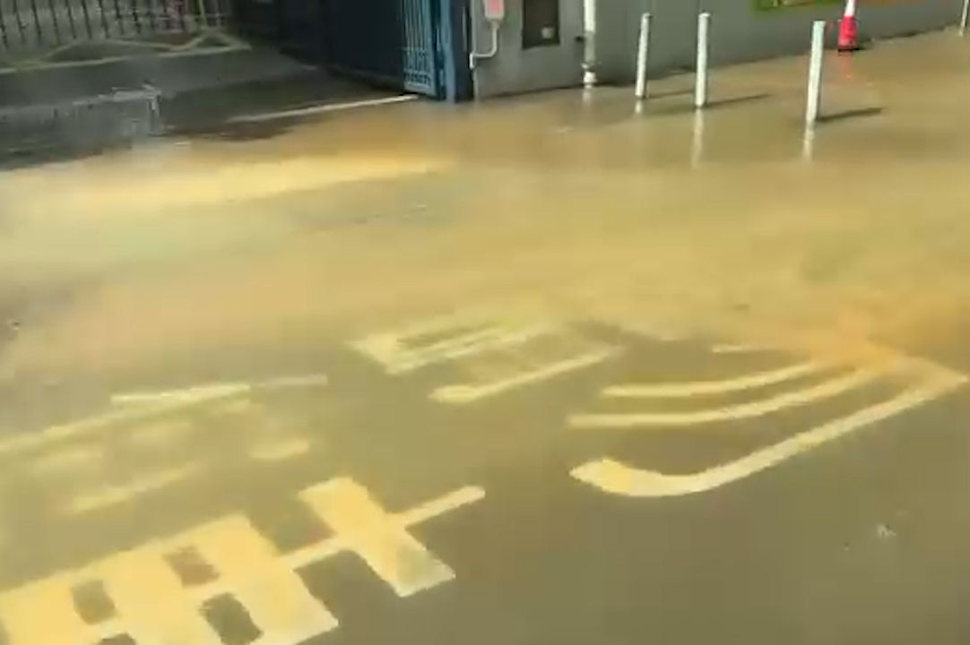 青衣警署正門前爆水管，泥水淹行人路及馬路。(現場影片截圖)