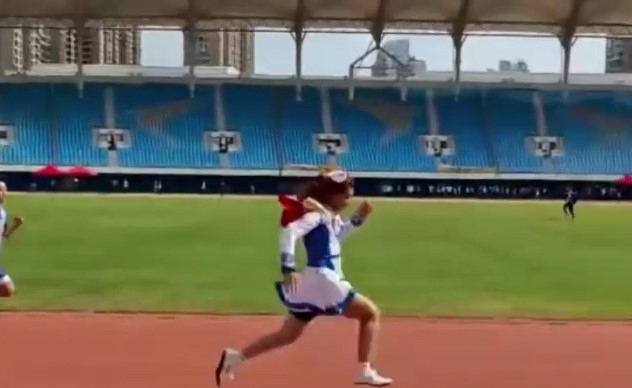 在廈門市松柏中學學校運動會中，一名男學生身穿裙子、戴假髮，參加跑步比賽，並以大幅領先的優勢奪冠。（網上影片截圖）