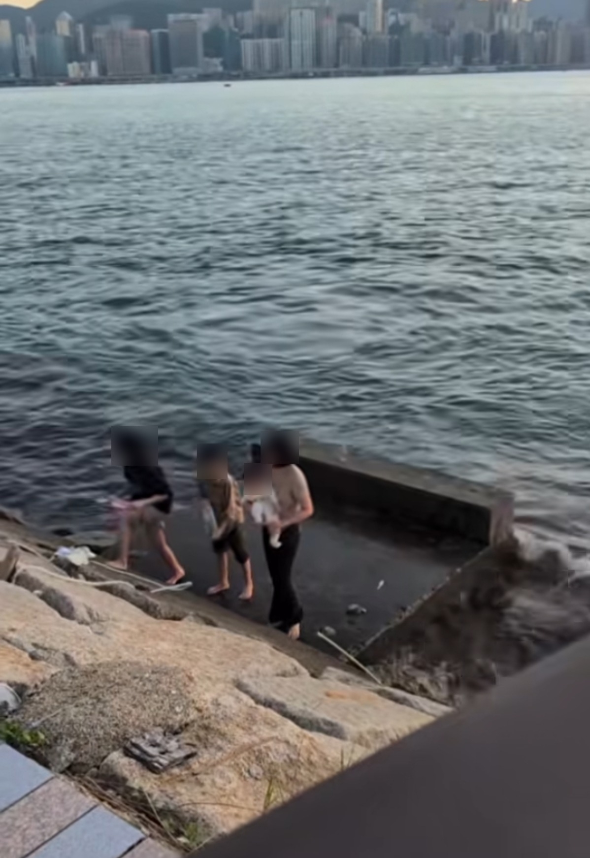 有市民於啟德海濱拍攝影片並上載至社交平台，指一名成年人懷抱嬰兒，與另外兩名小童一同走到海濱斜坡下的平台遊玩。