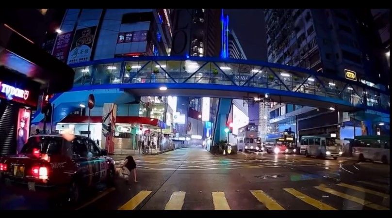 銅鑼灣內地女冒雨急步「衝紅燈」，插水跣入的士底險遭輾過。