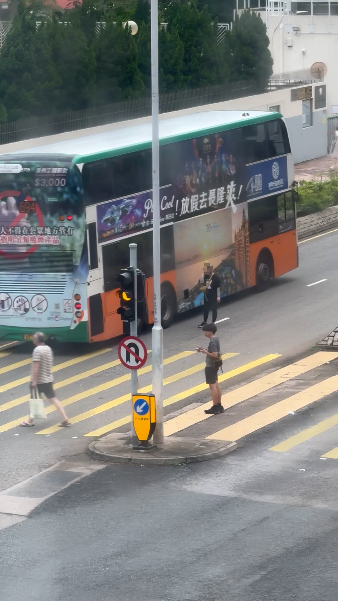 涉事女子站在馬路時，曾經有私家車及雙層巴士在她身邊駛過，但她完全無視相關車輛。（報料觀眾提供影片截圖）
