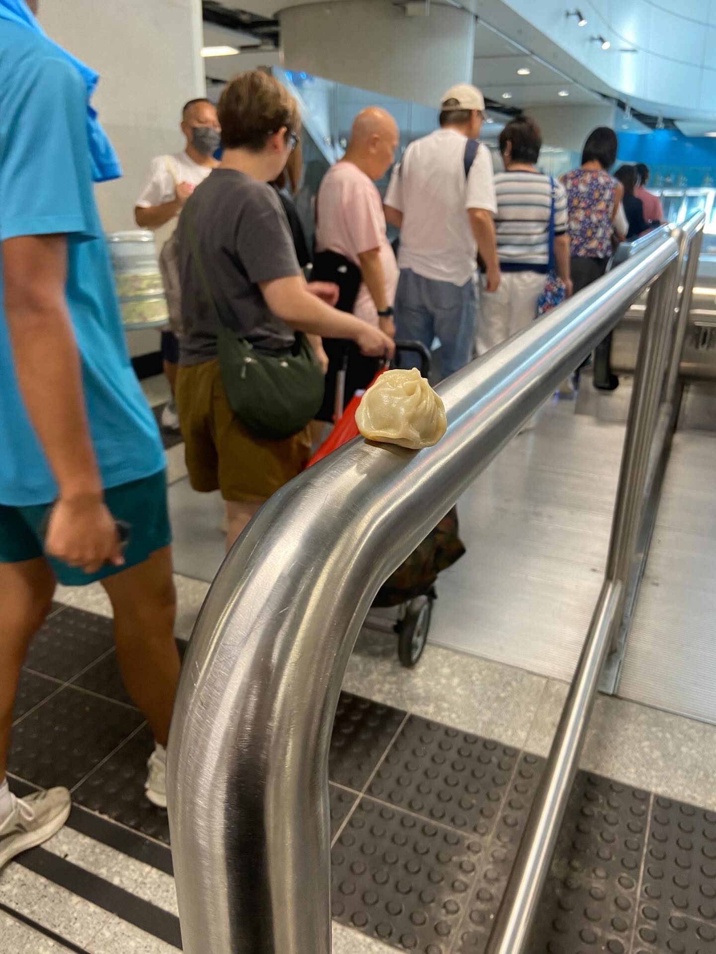 在金鐘站一處扶手電梯前，有一個小籠包被放置在欄杆上。（Threads圖片／felix.prfm）